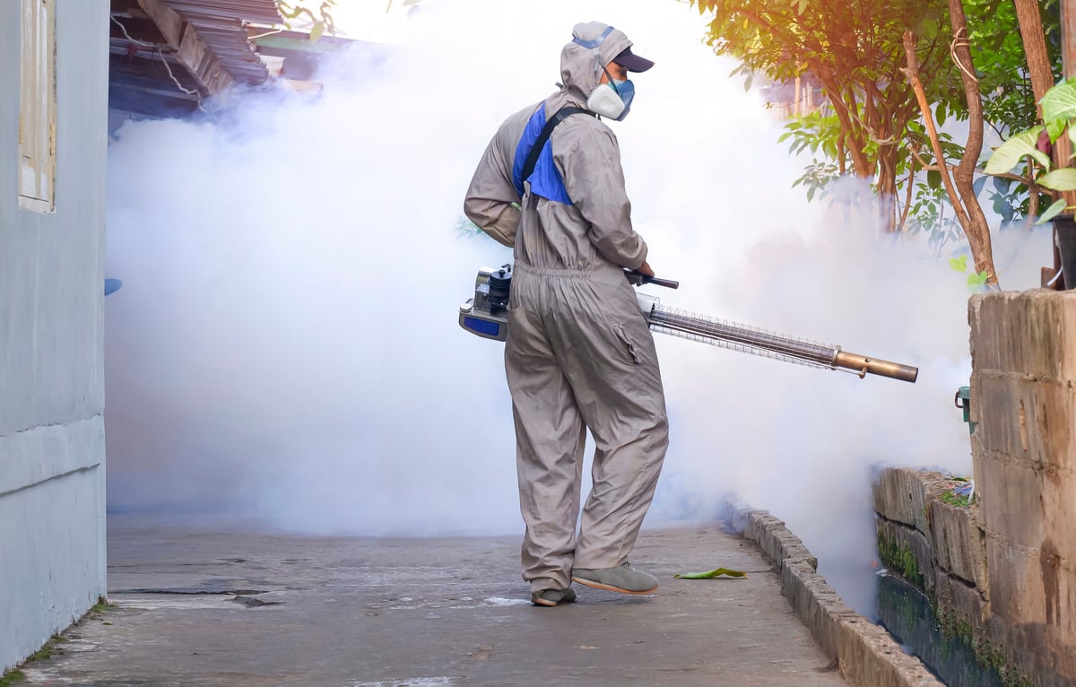 Outdoor worker using a fogging machine to spray fumigation chemical to eliminate mosquitoes, created as an independent concept for a fumigation service website