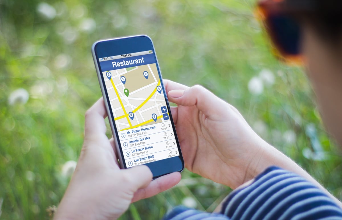 Person using a smartphone to find local business listings for a county guide website