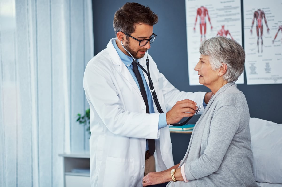 Doctor examining a senior patient with a stethoscope in a clinic, created as an independent concept for a medical practice website